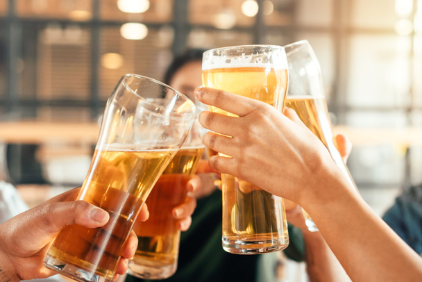 Μερική άποψη των ανθρώπων που τσούγκριζαν ποτήρια με μπίρα στο μπαρ  - Φωτογραφία, εικόνα