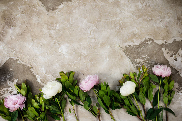 Fresh pink peonies flowers on aged wooden background. Flat lay. Top view with copy space. Selective focus. Toned image. - Photo, Image