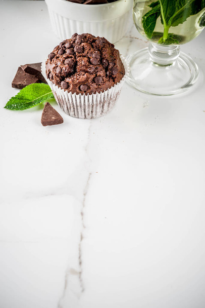 Huis gebakken mint en chocolade muffins met mint thee, witte marmeren achtergrond kopie ruimte - Foto, afbeelding