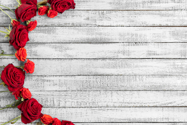 Το Top view από κόκκινα τριαντάφυλλα σε grungy γκρι ξύλινο τραπέζι με χώρο αντίγραφο - Φωτογραφία, εικόνα