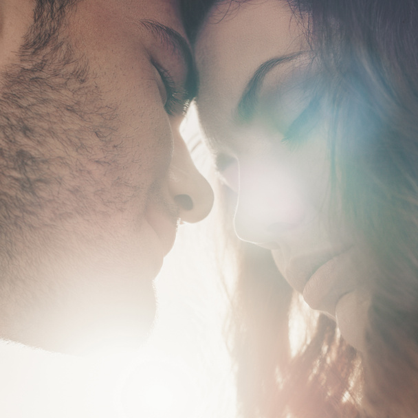 close up shot of sensual couple in love leaning head to head in front on sunlight - Photo, Image