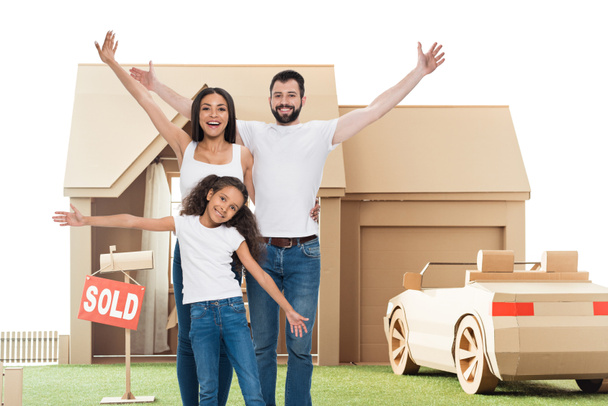 happy multi ethnic family with raised hands in front of new home - Photo, Image