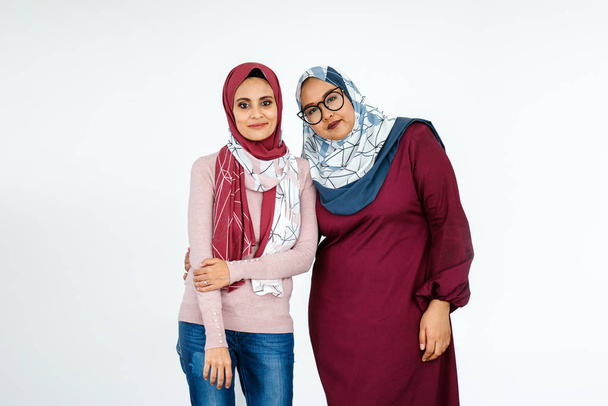 Portrait of two muslim women wearing hijabs posing on white background - Fotografie, Obrázek