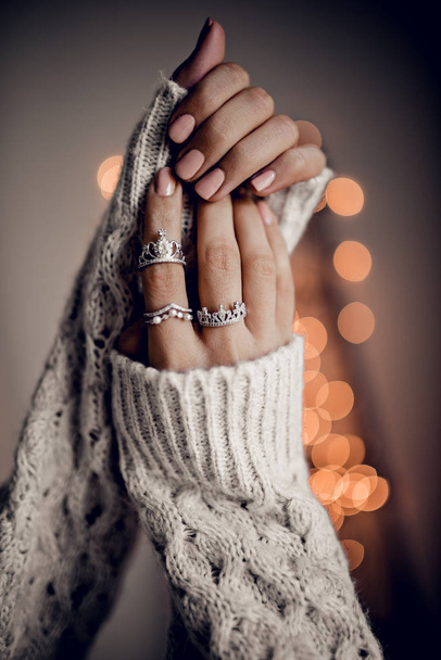 Hands with rings on golden bokeh lights background - Фото, изображение