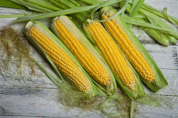 Fresh corn on cobs on rustic wooden table, close up. Sweet corn ears background - Foto, Imagen
