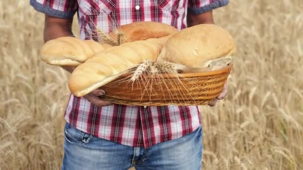 Manos para hombre sostienen una cesta con productos de panadería
 - Imágenes, Vídeo