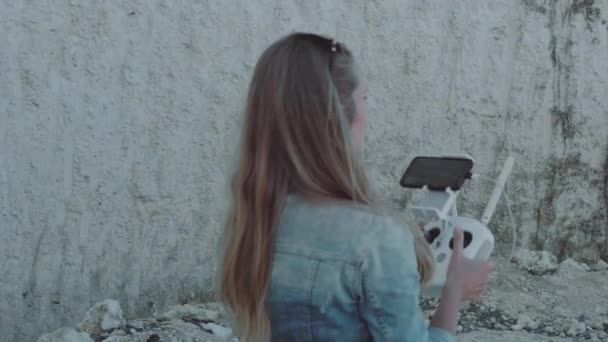 Mulher operando drone com controle remoto enquanto está perto de belas falésias brancas durante o dia ensolarado de verão - vídeo em câmera lenta
 - Filmagem, Vídeo