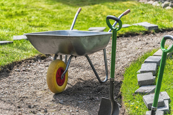 Picture of wheelbarrow in the backyard with green grass - Photo, Image