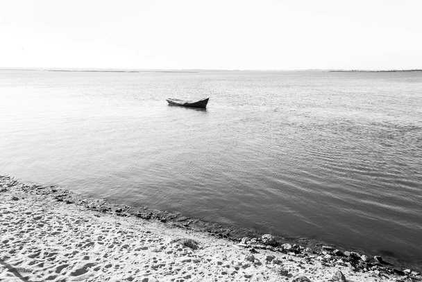 海にまだ立っている空のボートを分離しました。黒と白のシーン。ウルグアイ、プンタ ・ デル ・ エステ. - 写真・画像