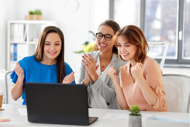 happy businesswomen with laptop at office - Fotó, kép