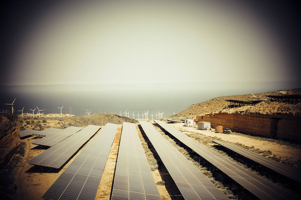 Elektrownia słoneczna energia środowisko produkcji nowoczesnego przyszłych energii elektrycznej z słońce i wiatr młyny w górach z widokiem na ocean. nowy świat bez zanieczyszczeń i węgla - Zdjęcie, obraz