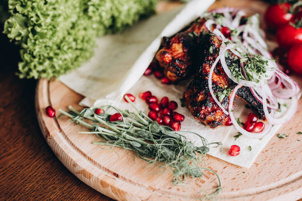 Grilled meat with fresh herbs, vegetables  on rustic wooden board - Foto, Imagem