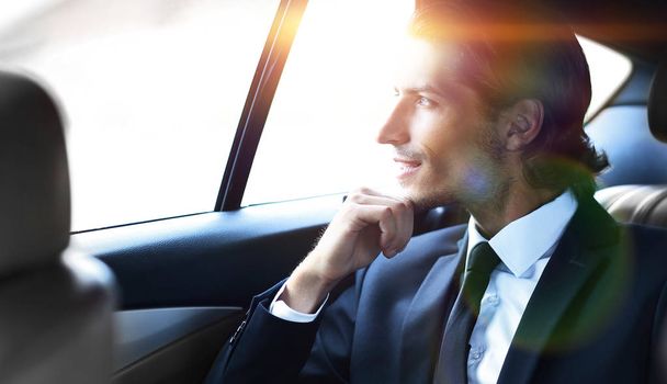 successful man sitting in the back seat of a car - Фото, изображение