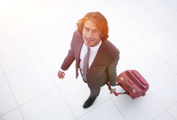 smiling businesswoman with travel suitcase - Foto, Bild