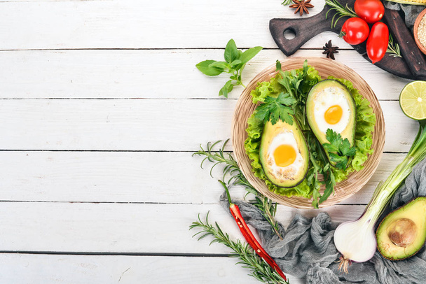 Baked avocado with egg. Healthy food. On a wooden background. Top view. Copy space. - Foto, Bild