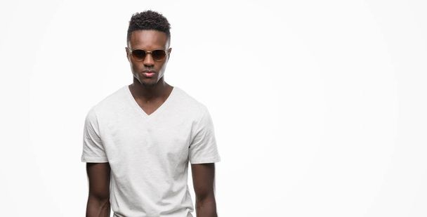 Молодий афроамериканець людиною носити сонцезахисні окуляри з виразом впевнено на смарт-обличчя мислення серйозні - Фото, зображення