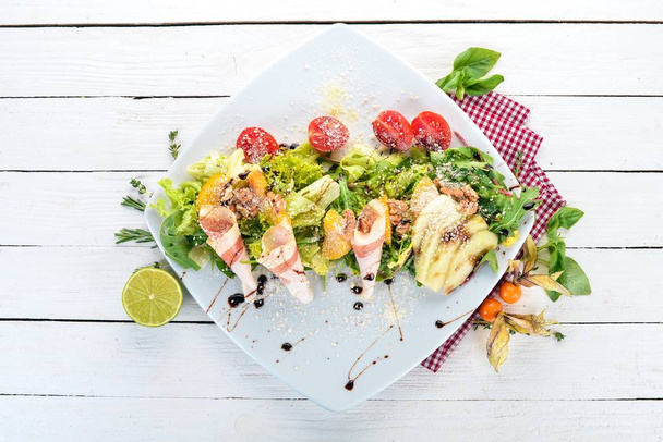 Fresh salad with bacon, avocado and tomatoes. On a wooden background. Top view. Copy space. - Fotografie, Obrázek