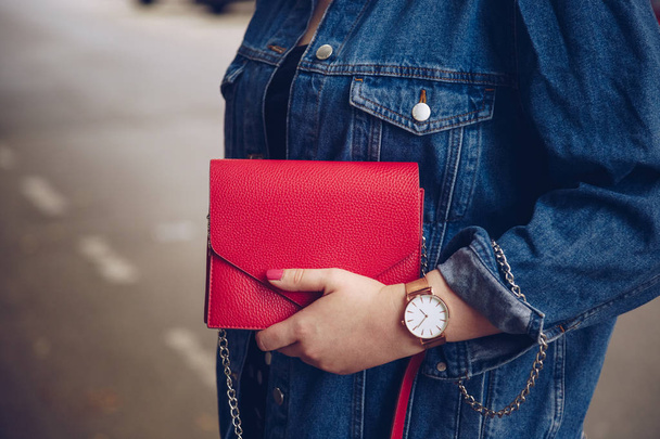kırmızı çanta tutarak ve bir gül altın bilek saati denim ceket şık kadın. sokak stil moda - Fotoğraf, Görsel