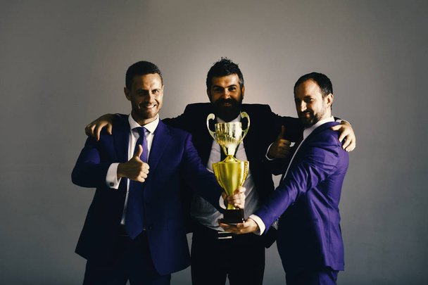 Men with beard and happy faces celebrate victory and leadership. Businessmen wear smart suits and ties. Career and competition concept. - Фото, изображение