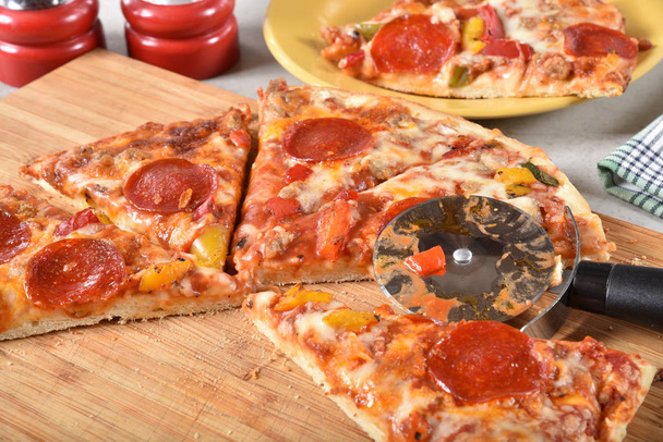 スライスしたペパロニとまな板の上のソーセージのピザ、新鮮なホットします。 - 写真・画像