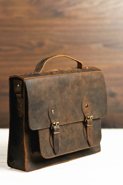 Bag briefcase for businessman men, leather brown bag on a wooden background. Men's fashion, accessory, business background. Selective focus. - Photo, Image