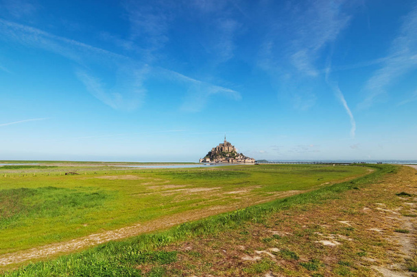 Way to the famous Mont Saint Michel abbey. It is one of the most famous tourist attractions in France. Landscape photo during sunrise. Normandy, France. - Photo, Image