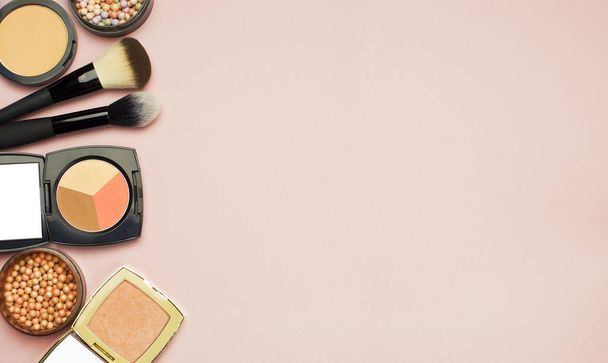 Joukko värikkäitä kosmetiikka Powder Rouge Corrector Harjat vaaleanpunainen tausta. Meikki tarvikkeet Top view
 - Valokuva, kuva