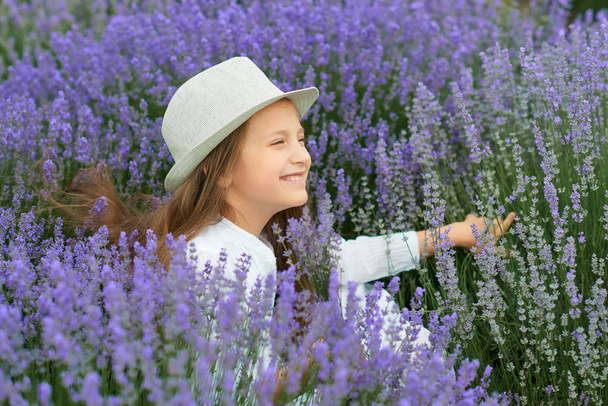 child girl is in the lavender field, beautiful portrait, face closeup, summer landscape - Foto, Imagen