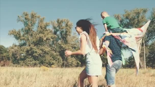 Happy family, mom, dad and son are walking in nature, launching an air snake. Stock footage. - Imágenes, Vídeo