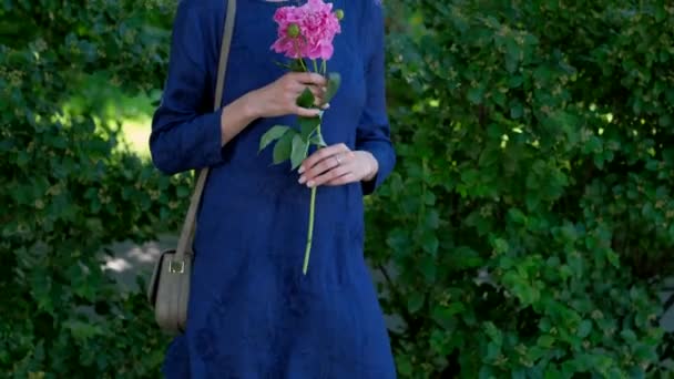 Young woman with peony flower - Materiał filmowy, wideo