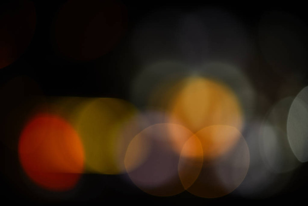 Lights of christmas garland blurred on black background. Lights of colorful garland defocused as beautiful background. Christmas holiday decoration blurred. Background concept - Fotografie, Obrázek