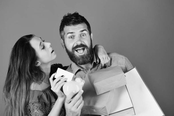 Shopping and free time concept. Guy with beard and girl with excited faces do shopping. - Foto, Imagem