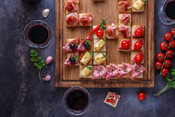 Зовнішній стіл з італійськими антипастними закусками та вином у склянках. Brushetta або автентичний традиційний лат. spanish tapas set, сирна дошка на сірому бетонному тлі. Верхній вид, плоский - Фото, зображення