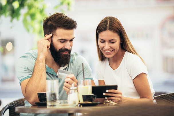 Couple having coffee on a date, using digital tablet. - Photo, Image