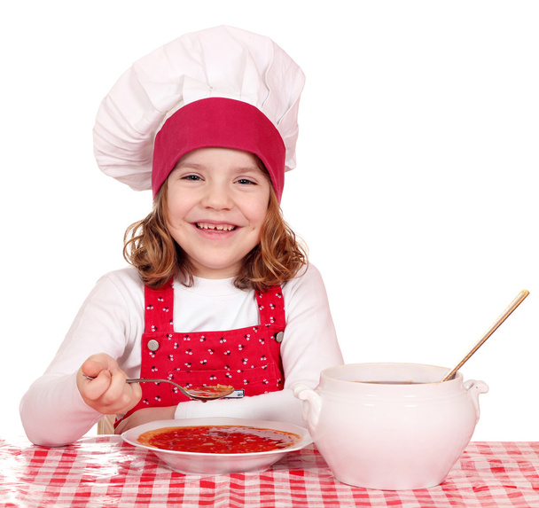 happy little girl cook eating soup - Φωτογραφία, εικόνα