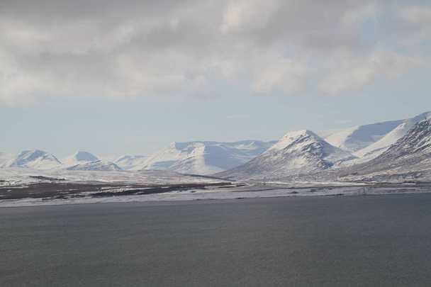 Kauniit talvimaisemat Islannissa. Vuoristojoet ja ihana jäämeri. Kalliomaata, korkeita vuoria, dramaattinen taivas. Eeppiset ja majesteettiset maisemat ja Islannin luonto
.  - Valokuva, kuva