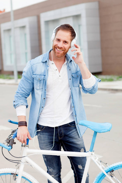 man with bicycle and headphones in city  - Foto, Imagem