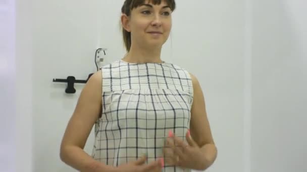 Young woman trying on clothes. Tilt view of attractive smiling caucasian female looking in the mirror trying on blouse in clothing stores fitting room. - Filmagem, Vídeo