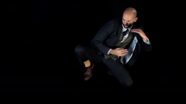 skillful male dancer in a smart suit dancing in a contemporary style on black background - Metraje, vídeo