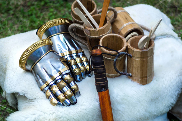 Ortaçağ şövalyesi metal el eldiven ve ahşap Kupası beyaz kürk battaniye içki için. Geleneksel şövalyeler silah ve teçhizat orta yaş Tema Festivali'nde. Yakın, seçici odak - Fotoğraf, Görsel