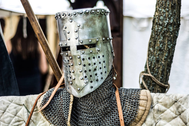 Средневековый старый рыцарский шлем и кольчуга для защиты в бою. Очень тяжелый головной убор на стенде в природе. Средневековые доспехи
 - Фото, изображение