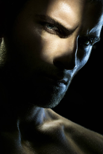 Близкий взгляд портрет сильного человека в тени
  - Фото, изображение