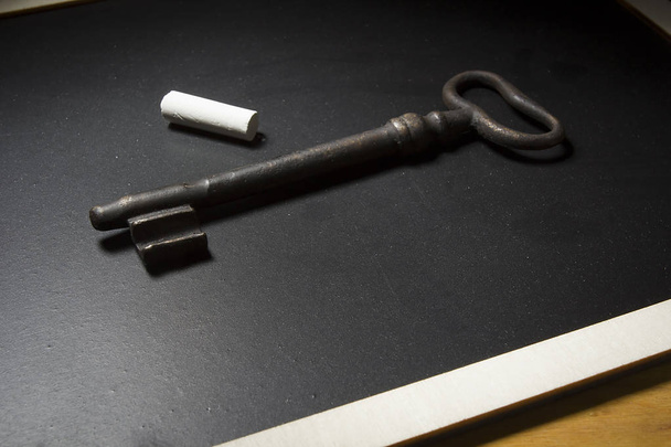 Velha chave enferrujada em uma ardósia preta
 - Foto, Imagem