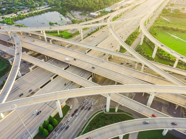Aerial view massive highway intersection, stack interchange with elevated road junction overpass at late afternoon in Houston, Texas. This five-level freeway interchange carry heavy rush hour traffic. - Photo, Image
