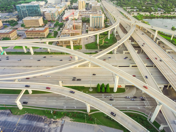 Luftaufnahme massive Autobahn-Kreuzung, Stapel-Kreuzung mit erhöhten Straßenüberführung Kreuzung am späten Nachmittag in Houston, Texas. Dieses fünfstöckige Autobahnkreuz sorgt für dichten Berufsverkehr. - Foto, Bild