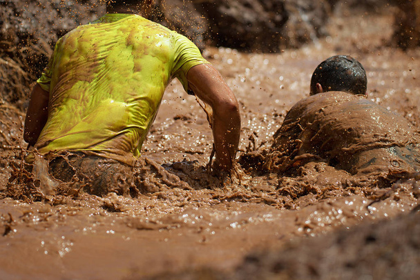 Corredores de corrida de lama, durante corridas de obstáculos extremos
 - Foto, Imagem