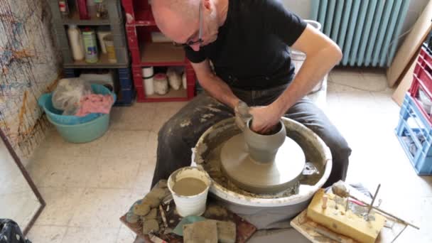 Ceramik w pracy na kole potter w warsztacie - Materiał filmowy, wideo