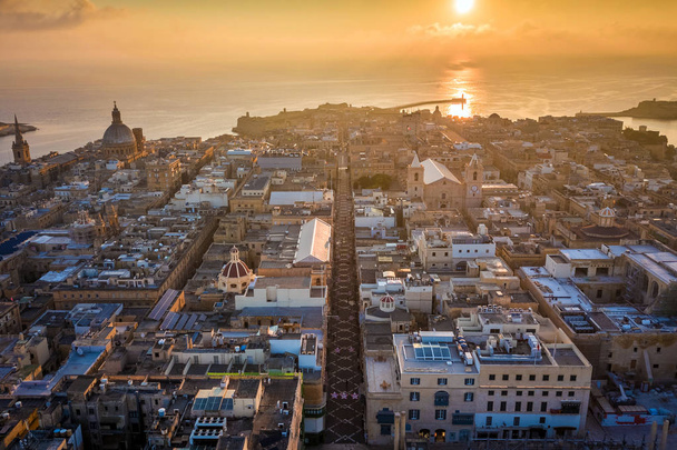 La Valeta, Malta - Salida del sol y la antigua ciudad de La Valeta desde arriba con Triq Ir-Repubblika, la estrecha calle principal de La Valeta
 - Foto, Imagen