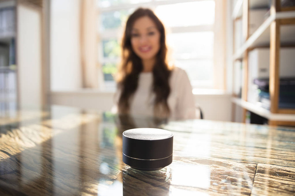 Close-up Of Wireless Speaker In Front Of Businesswoman Listening To Music - Foto, Imagem