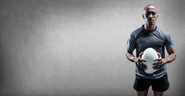 Digital composite of Rugby player holding ball with blank grey background - Zdjęcie, obraz